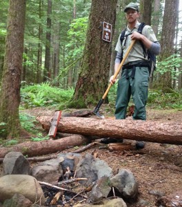 Jonathan Erickson beside a campfire next a sign reading: "No Camping, No Fires"