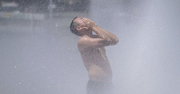 Heat wave PNW 2021, guy cools off in fountain in Portland