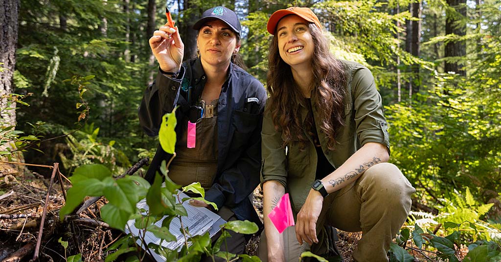 Ashley Russell (left) and Tessa Chesonis survey an Oregon forest.