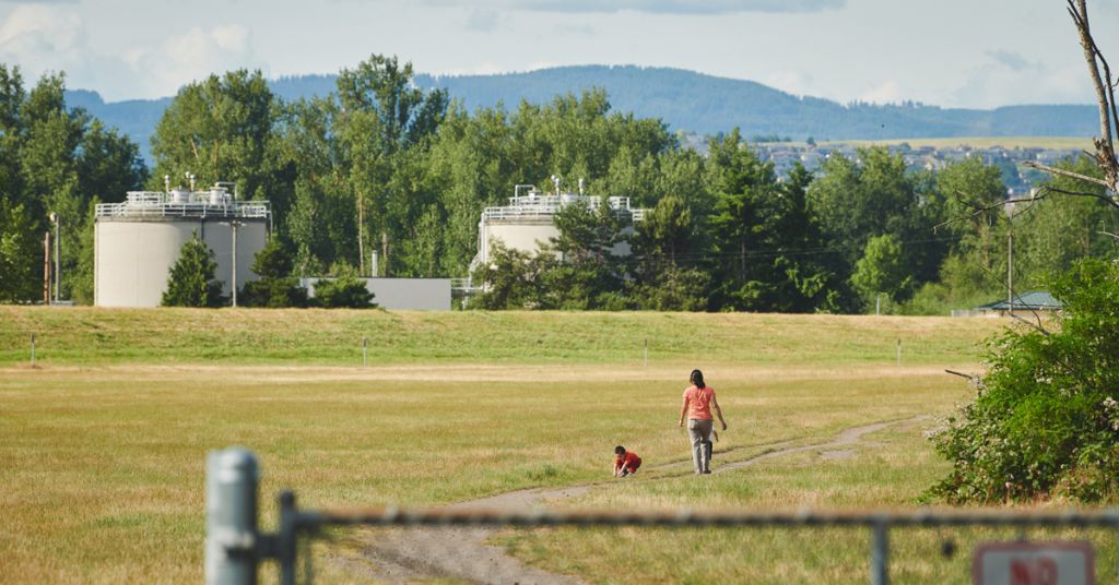 A family walks on a path next to the Sandy River in Troutdale, OR that connects to the 40-Mile Loop Trail that is part of the Troutdale Reynolds Industrial Park.