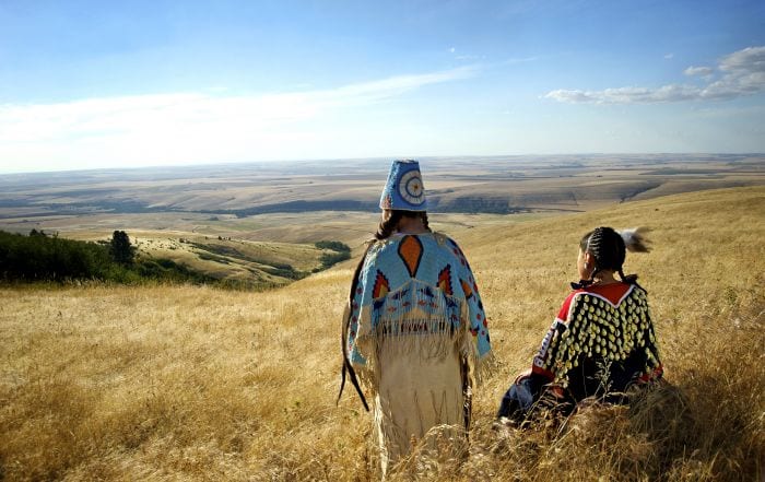 Girls in Umatilla beaded regalia of them looking west. Photo by Walters Photographers